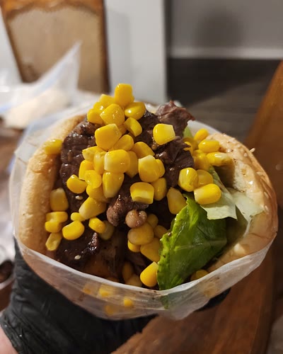 Brazilian burger piled with steak, sweet corn and lettuce