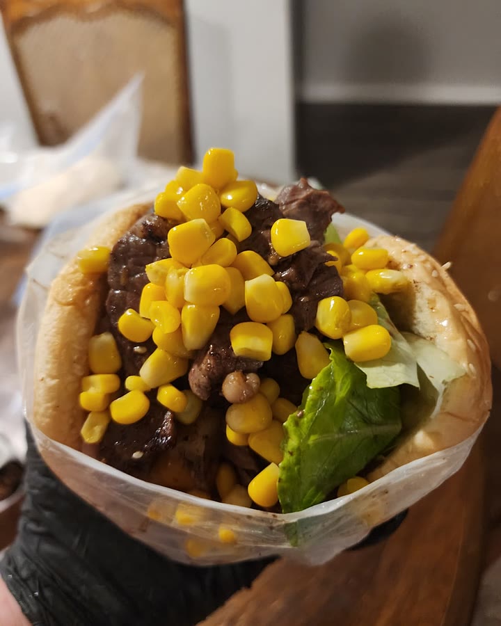 Brazilian burger piled with steak, sweet corn and lettuce