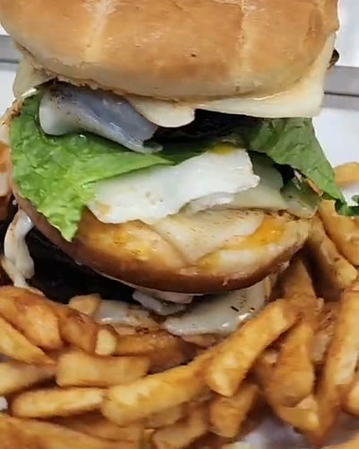 Tall Brazilian burger with egg, cheese and lettuce, served with fries