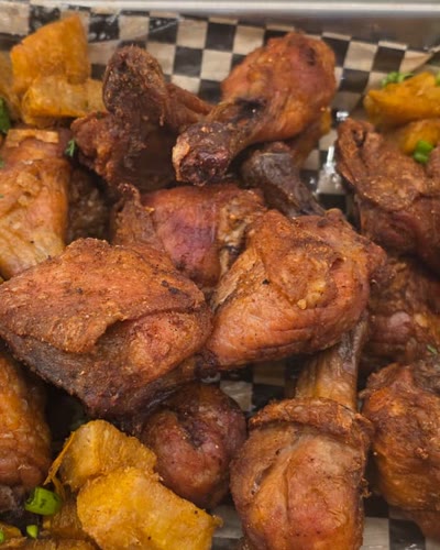 Tray of fried chicken pieces with fried cassava and green onion